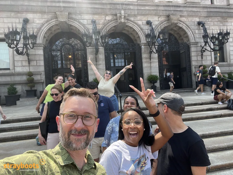 A group poses on the steps outside Boston Public Library.