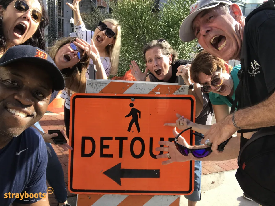 A group poses around an orange detour sign during an Orlando outing.